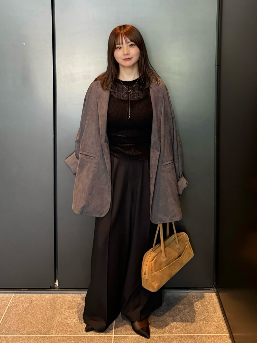 ブラック系のニット/セーター、ブラック系のキャミソール、グレー系のテーラードジャケットを着用したレディースの夏コーディネートの3枚目の写真