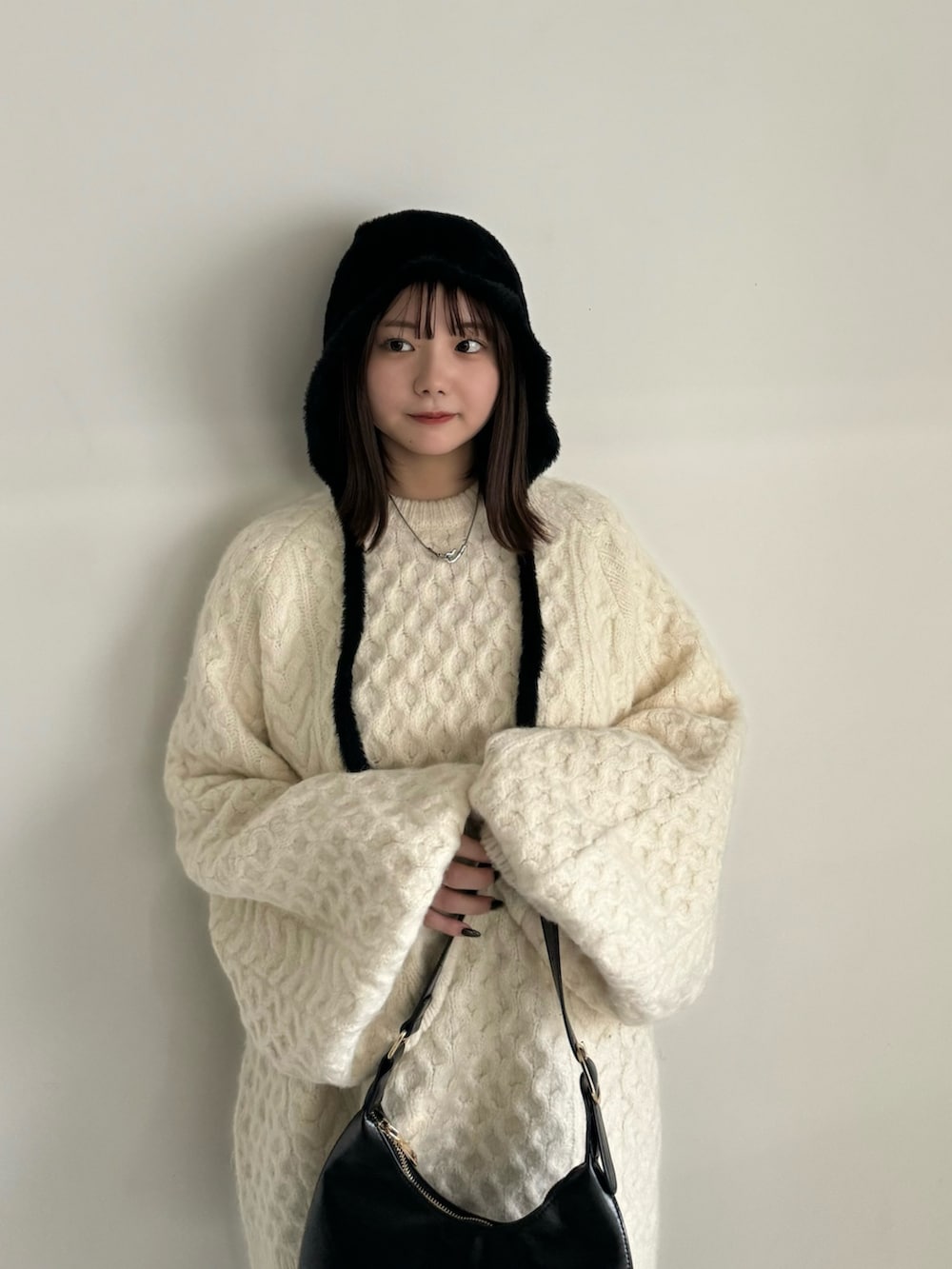 ホワイト系のニット/セーター、グレー系のその他パンツ、ブラック系のハンドバッグを着用したレディースの秋コーディネートの6枚目の写真