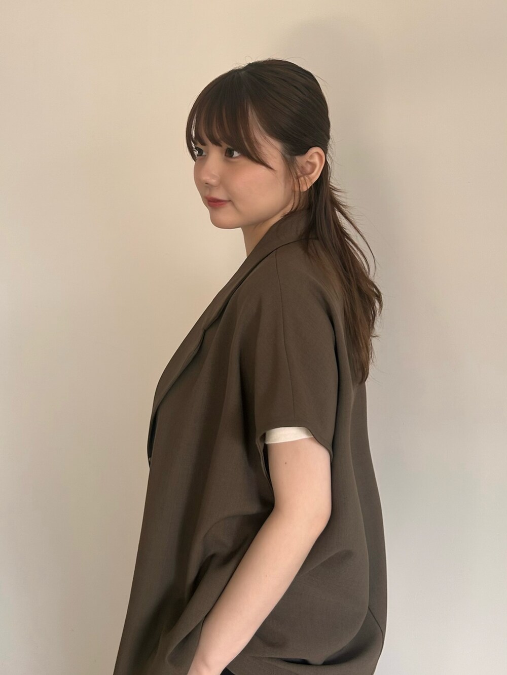 ブラウン系のテーラードジャケット、ベージュ系のTシャツ/カットソー、ブラック系のスラックスを着用したレディースの夏コーディネートの2枚目の写真