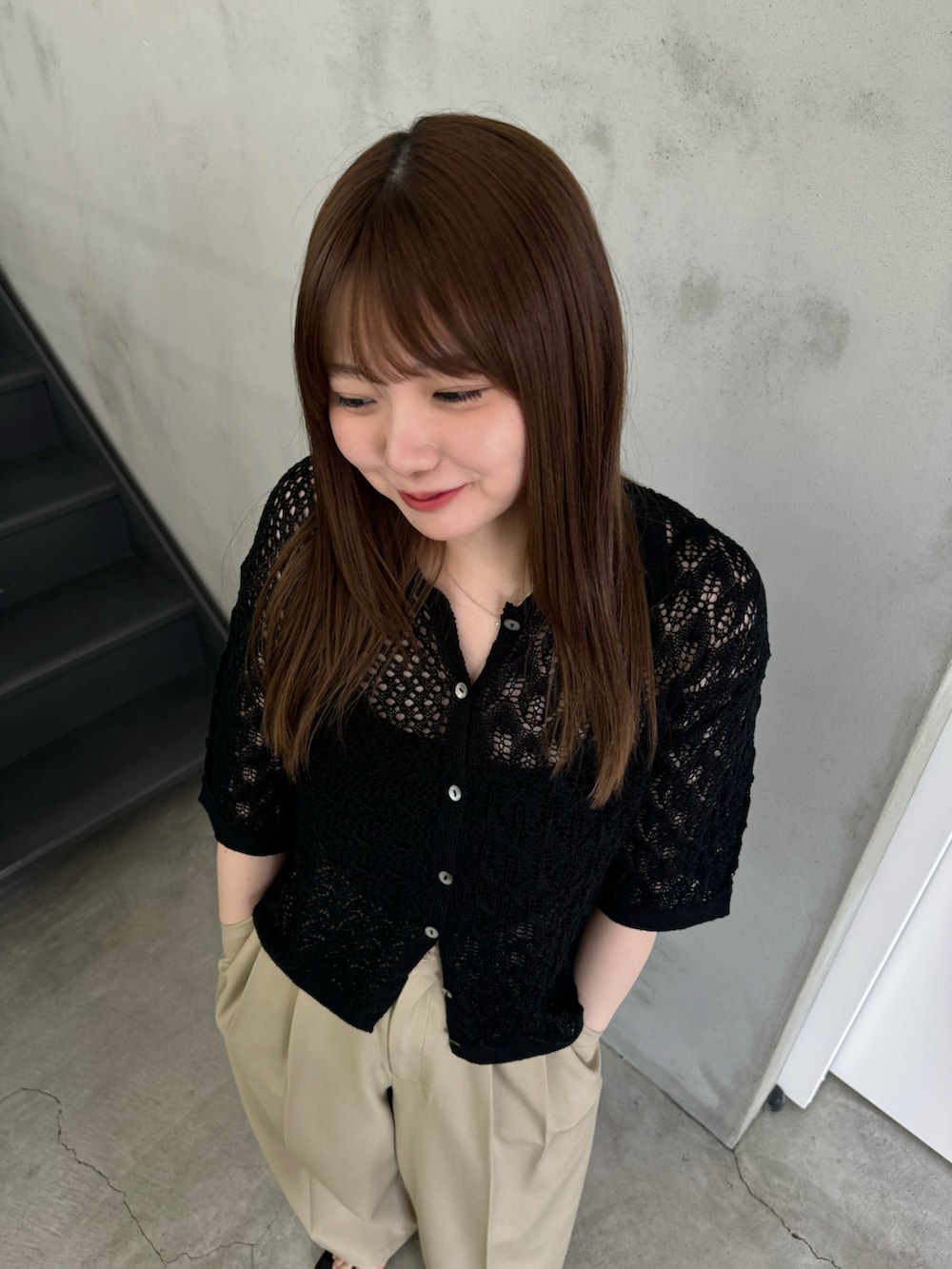 ブラック系のニット/セーター、ブラック系のキャミソール、ベージュ系のスラックスを着用したレディースの夏コーディネートの5枚目の写真