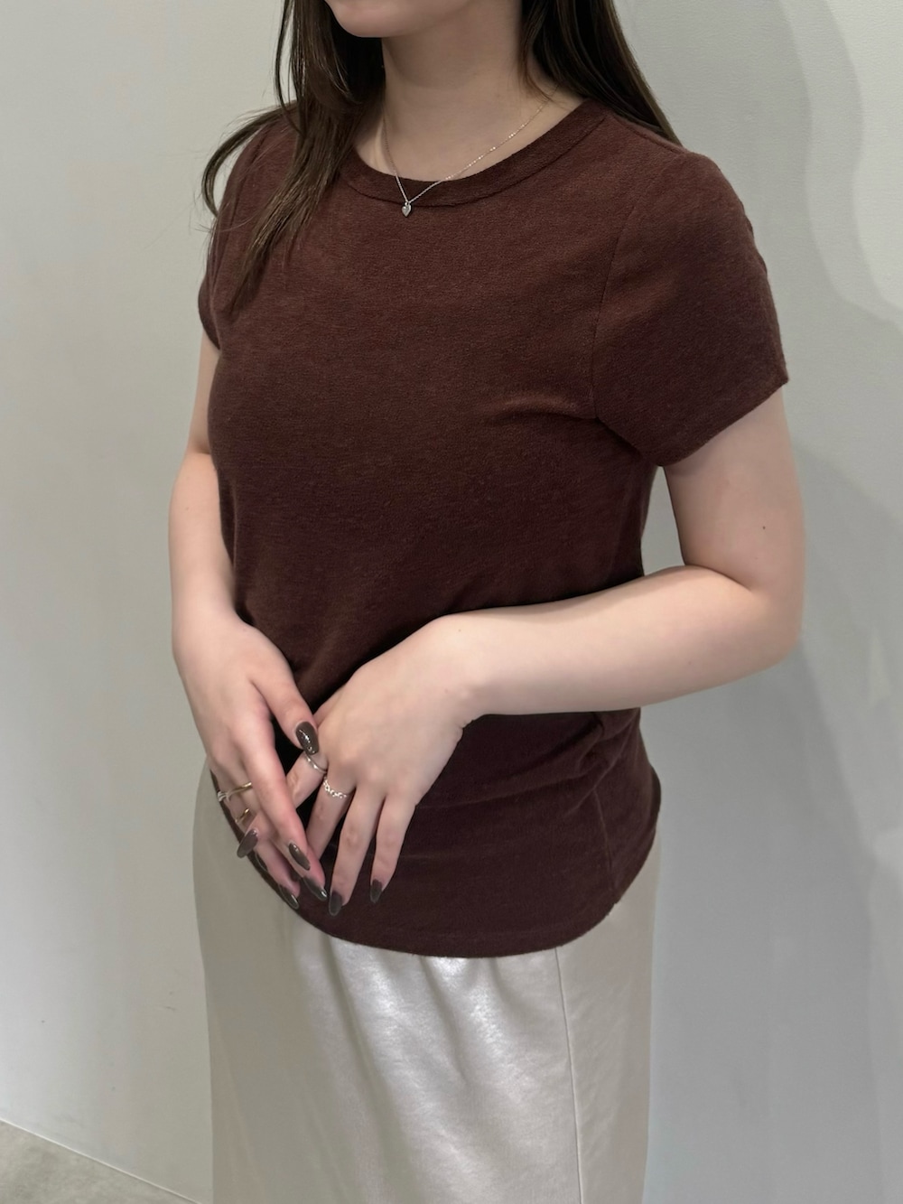 ブラウン系のTシャツ/カットソー、ホワイト系のスカートを着用したレディースの春コーディネートの2枚目の写真