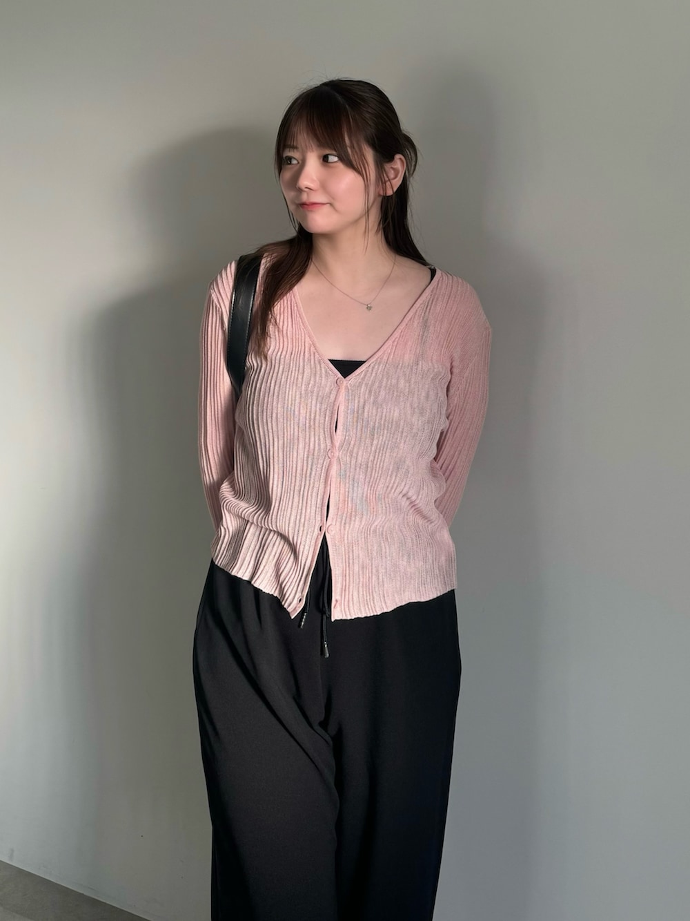 ブラック系のその他パンツ、ブラック系のスリッポン、ピンク系のカーディガン/ボレロを着用したレディースの春コーディネートの5枚目の写真