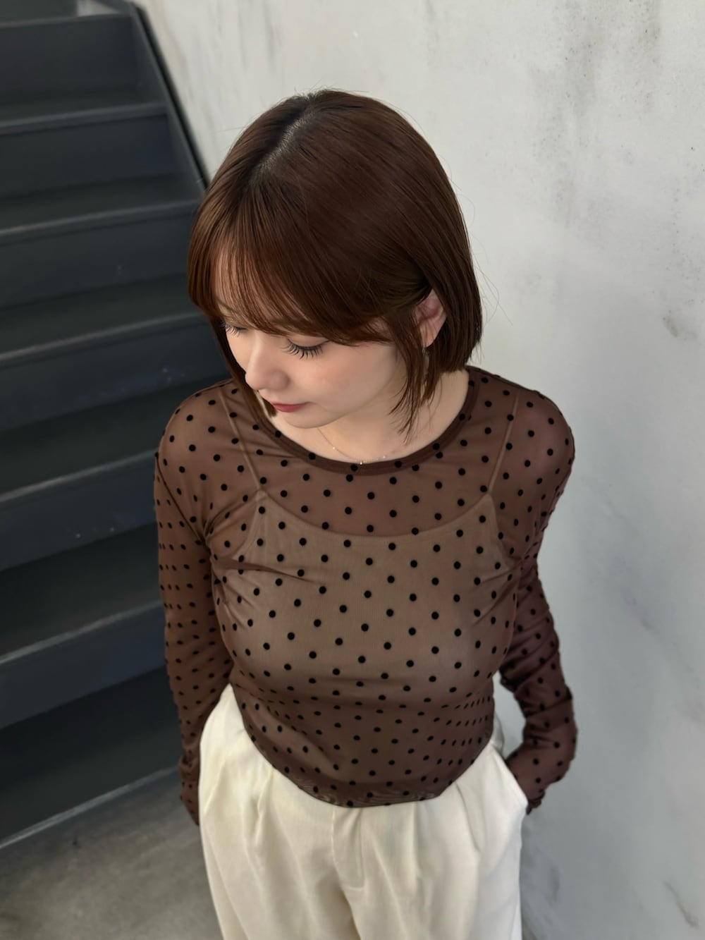 ブラウン系のTシャツ/カットソー、ベージュ系のキャミソール、ホワイト系のスラックスを着用したレディースの秋コーディネートの5枚目の写真
