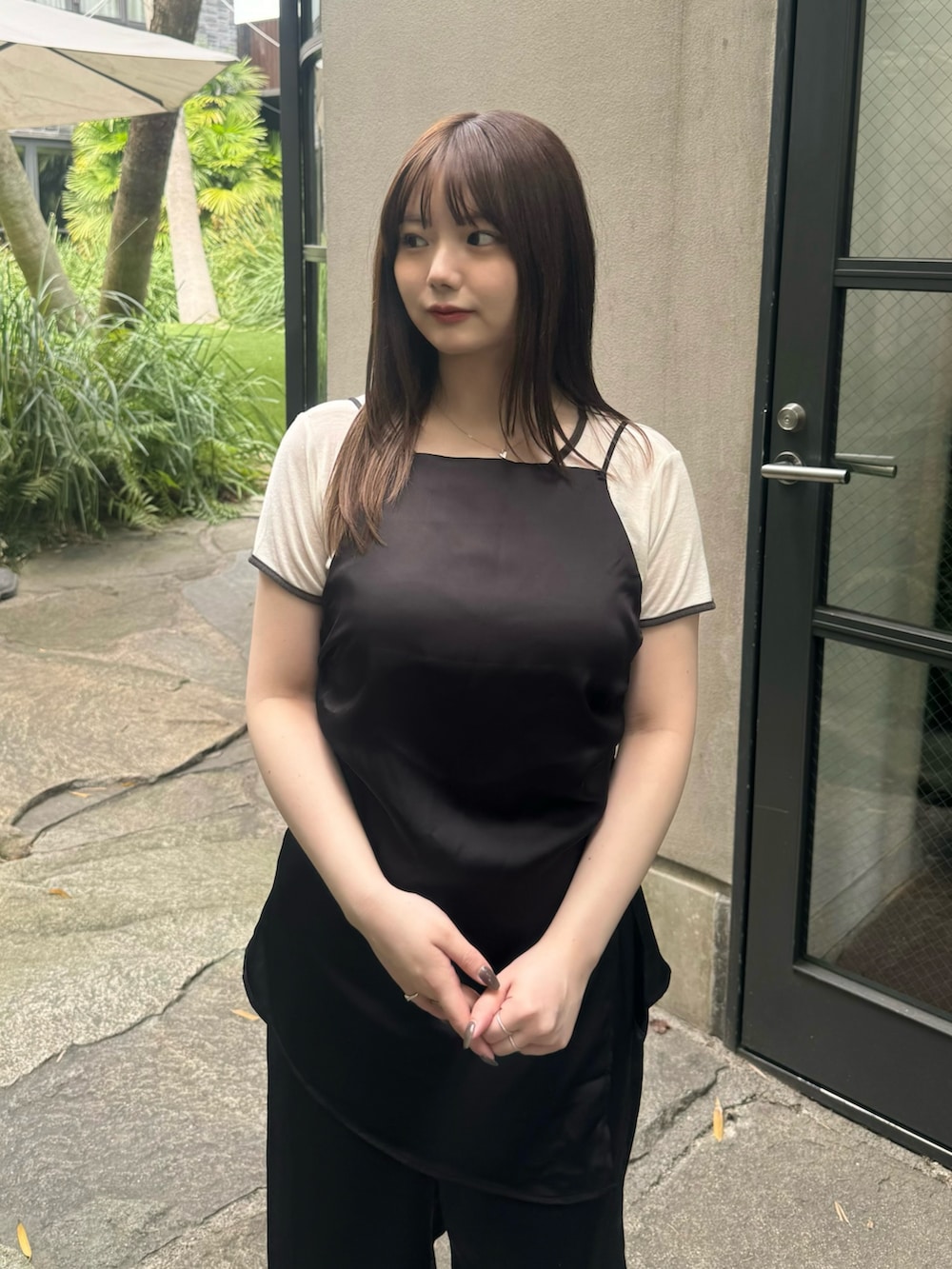 ブラック系のその他パンツ、ブラック系のキャミソール、ベージュ系のTシャツ/カットソーを着用したレディースの春コーディネートの3枚目の写真