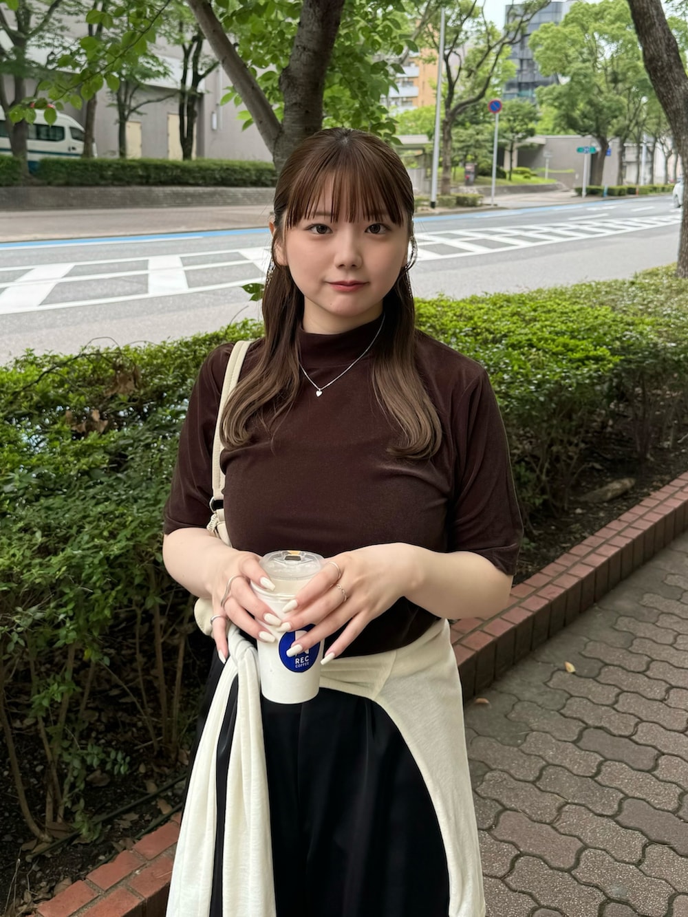 ブラウン系のTシャツ/カットソー、ホワイト系のハンドバッグ、ベージュ系のTシャツ/カットソーを着用したレディースの夏コーディネートの4枚目の写真