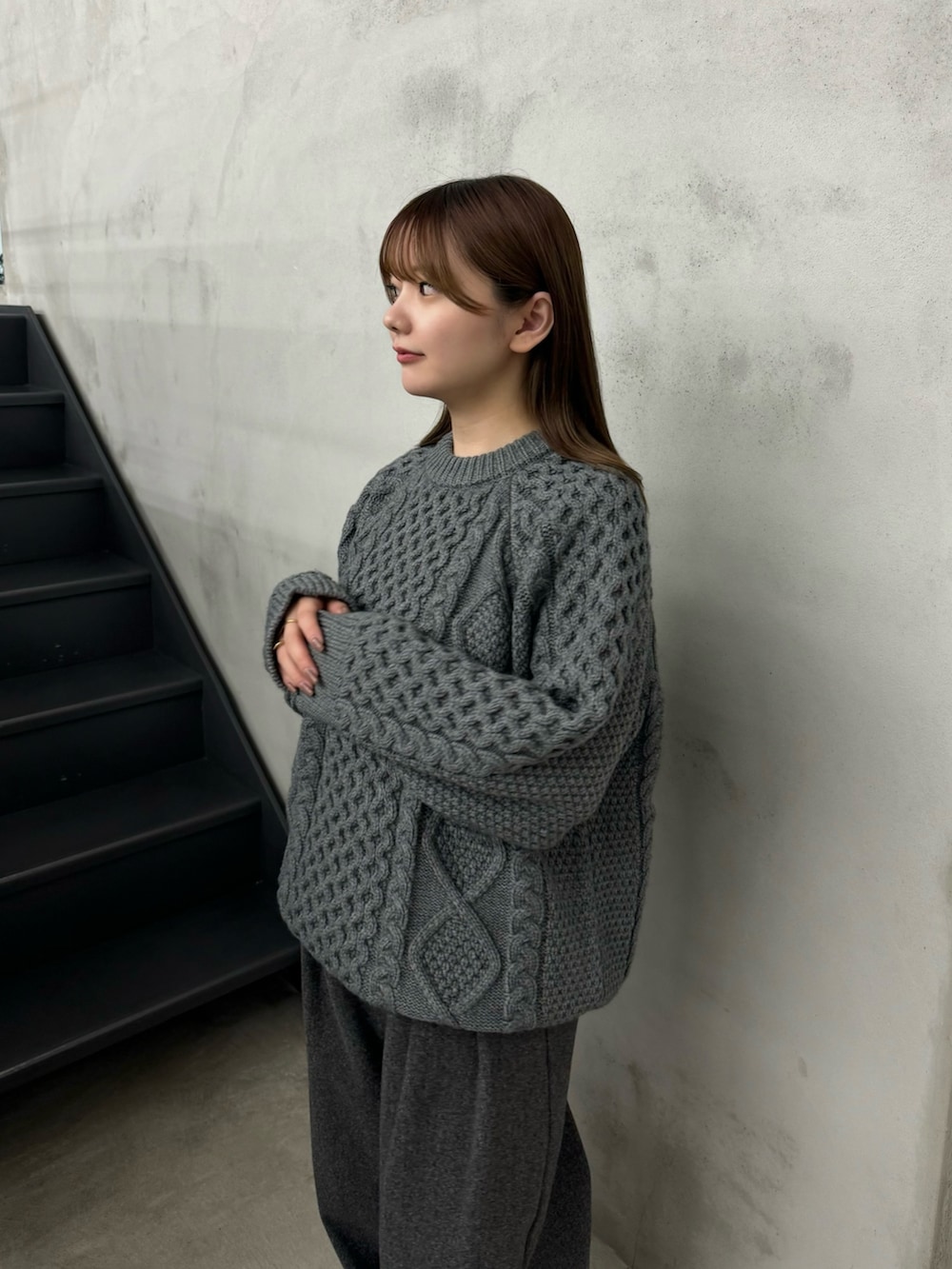 ブルー系のニット/セーター、グレー系のスラックス、ブラック系のローファーを着用したレディースの秋コーディネートの2枚目の写真