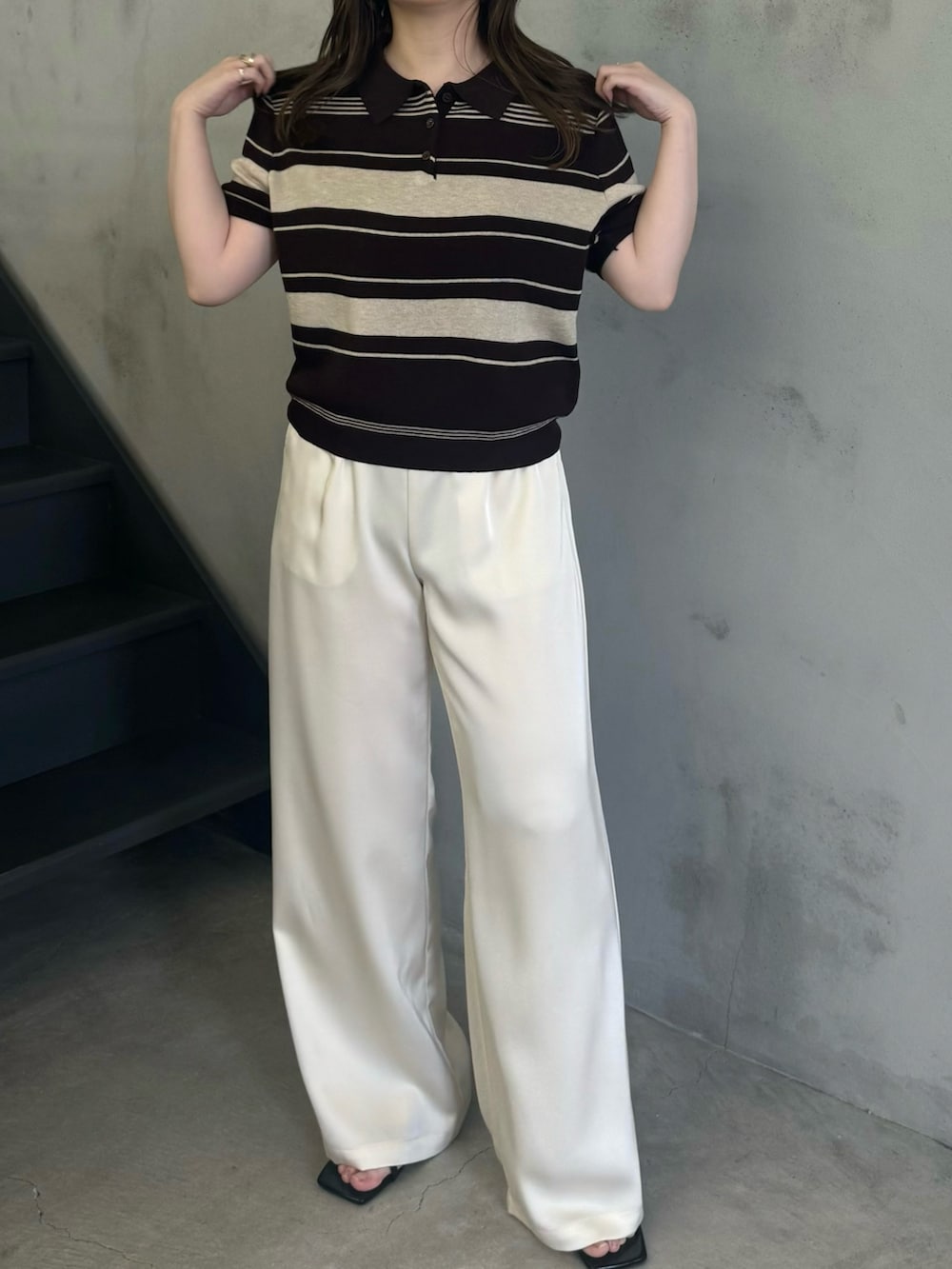 ブルー系のニット/セーター、ホワイト系のその他パンツ、ブラック系のサンダルを着用したレディースの春コーディネートの2枚目の写真