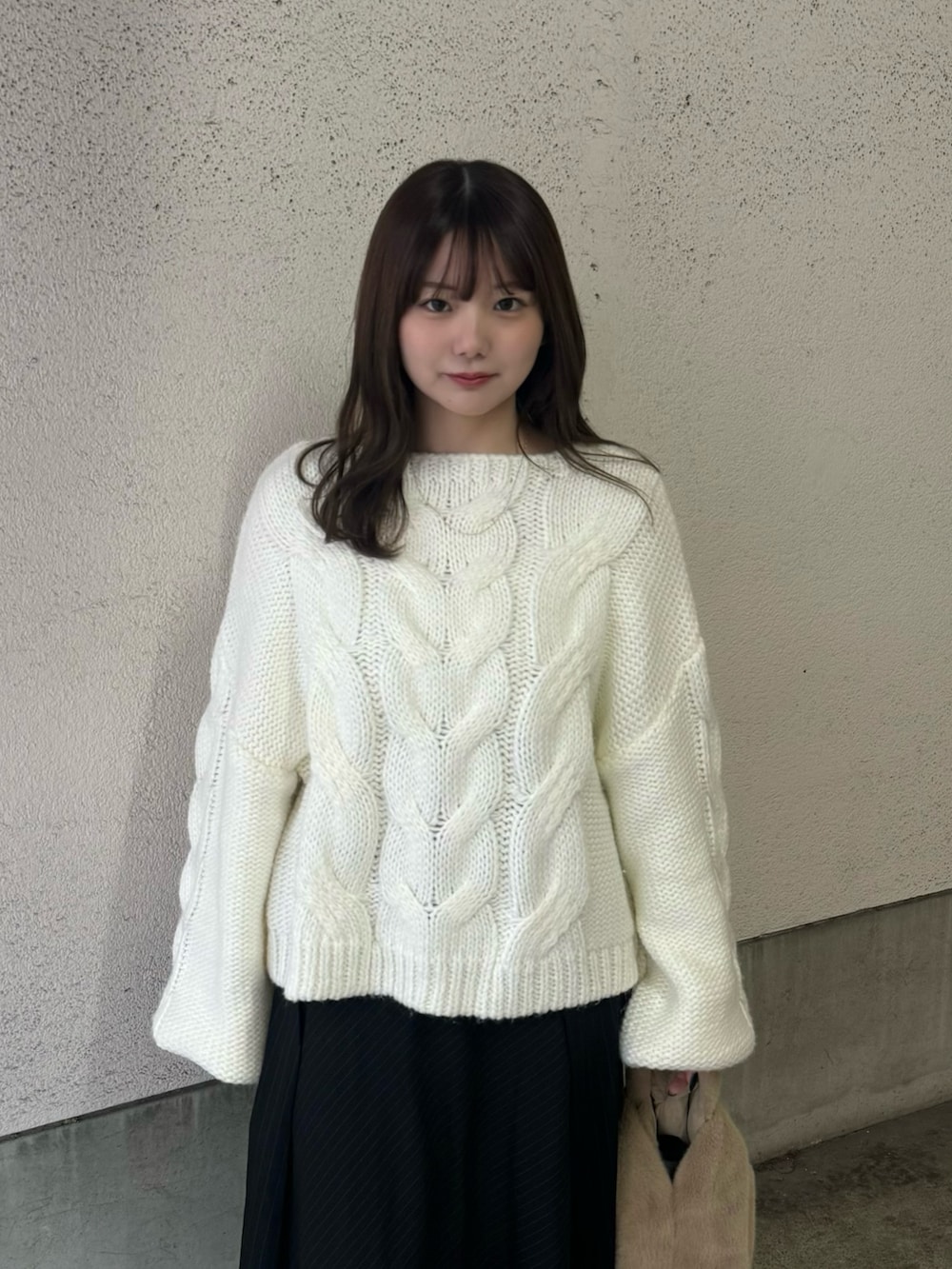 ホワイト系のニット/セーター、ブラック系のスカート、ブラウン系のローファーを着用したレディースの冬コーディネートの4枚目の写真