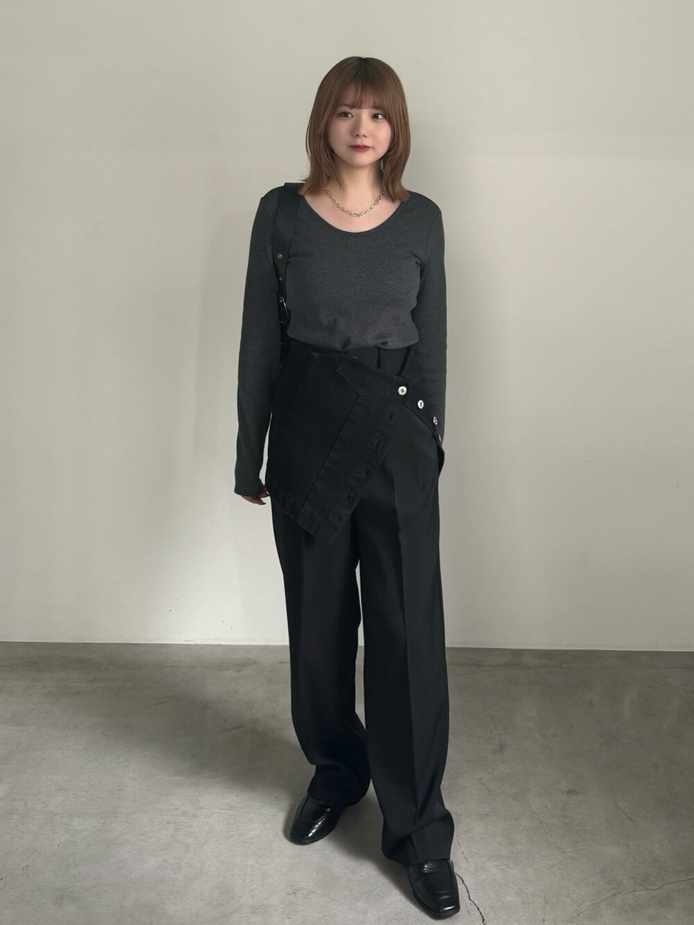 ブラック系のスラックス、ブラック系のチューブトップ、ブラック系のショルダーバッグを着用したレディースの春コーディネートの2枚目の写真