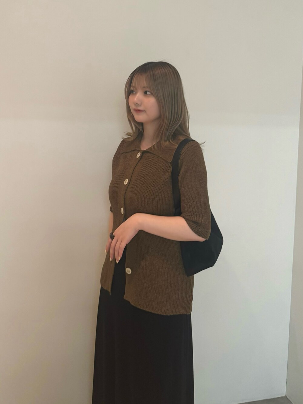 グリーン系のカーディガン/ボレロ、ホワイト系のキャミソール、ブラック系のスカートを着用したレディースの夏コーディネートの3枚目の写真