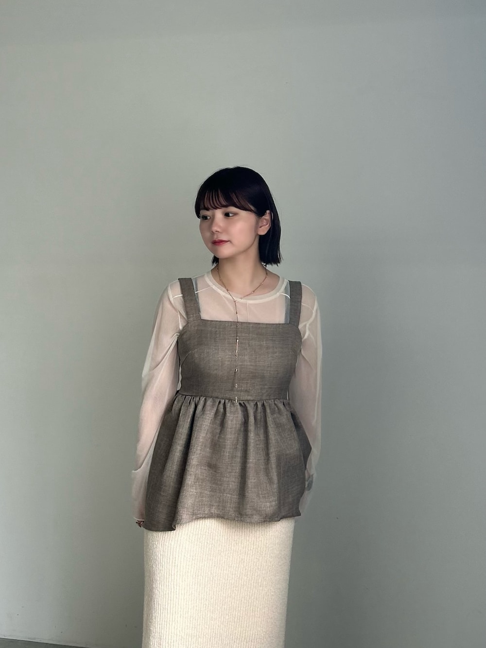 ホワイト系のTシャツ/カットソー、ブラウン系のキャミソール、ホワイト系のスカートを着用したレディースの夏コーディネートの4枚目の写真