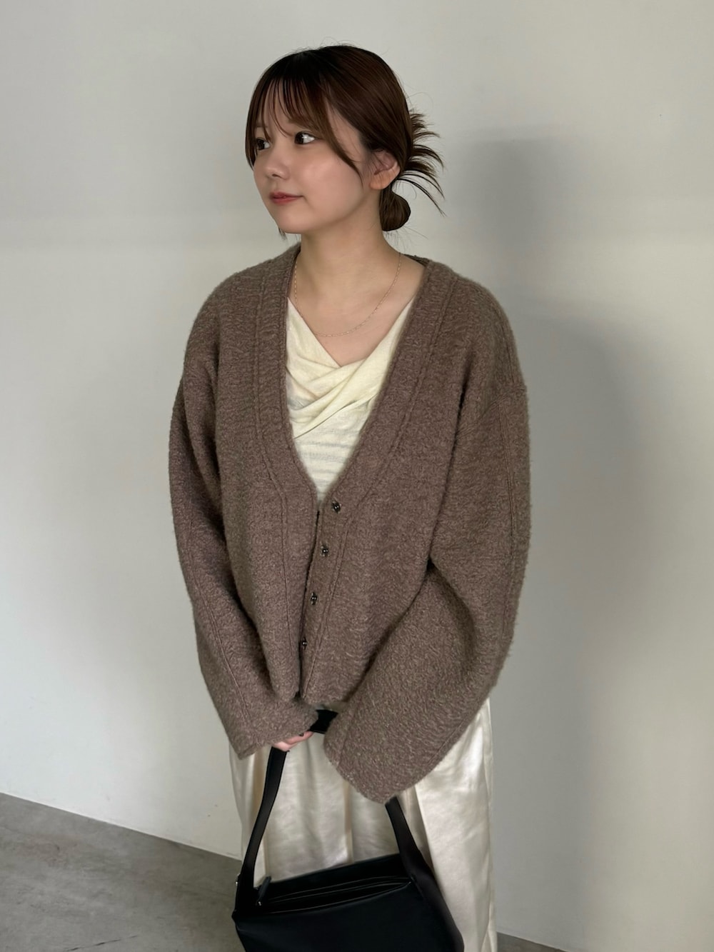 ホワイト系のTシャツ/カットソー、ベージュ系のカーディガン/ボレロ、ホワイト系のスラックスを着用したレディースの秋コーディネートの3枚目の写真