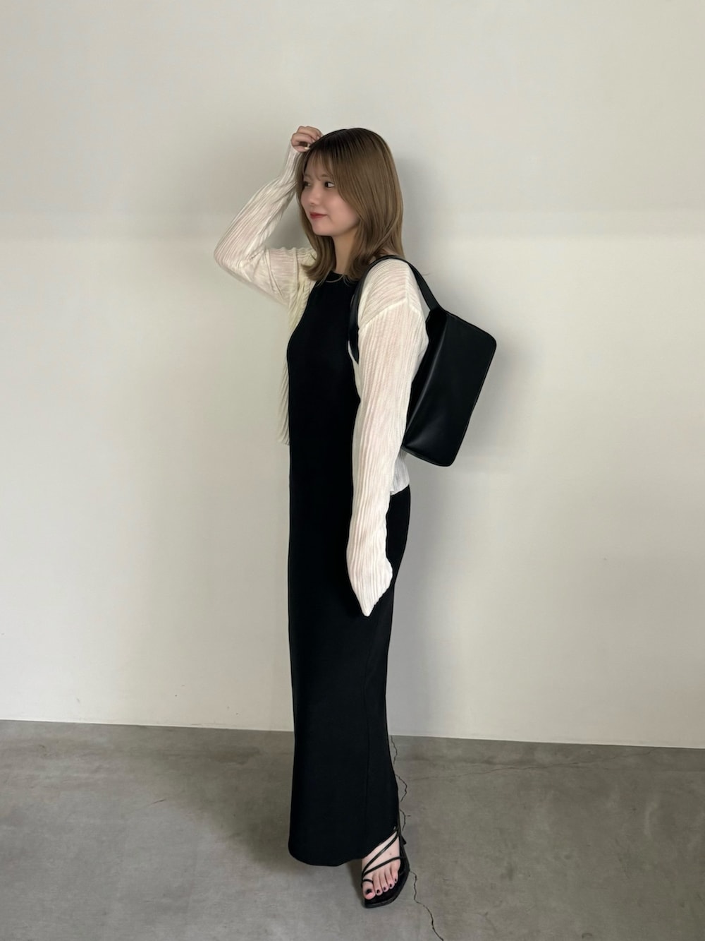 ブラック系のワンピース、ホワイト系のカーディガン/ボレロ、ブラック系のショルダーバッグを着用したレディースの夏コーディネートの4枚目の写真