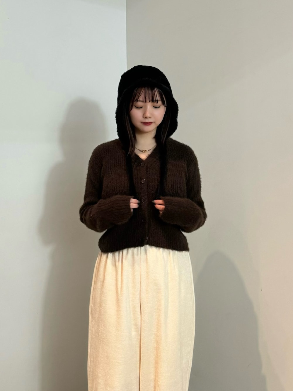 ブラウン系のカーディガン/ボレロ、ホワイト系のその他パンツ、ブラック系のブーツを着用したレディースの冬コーディネートの3枚目の写真