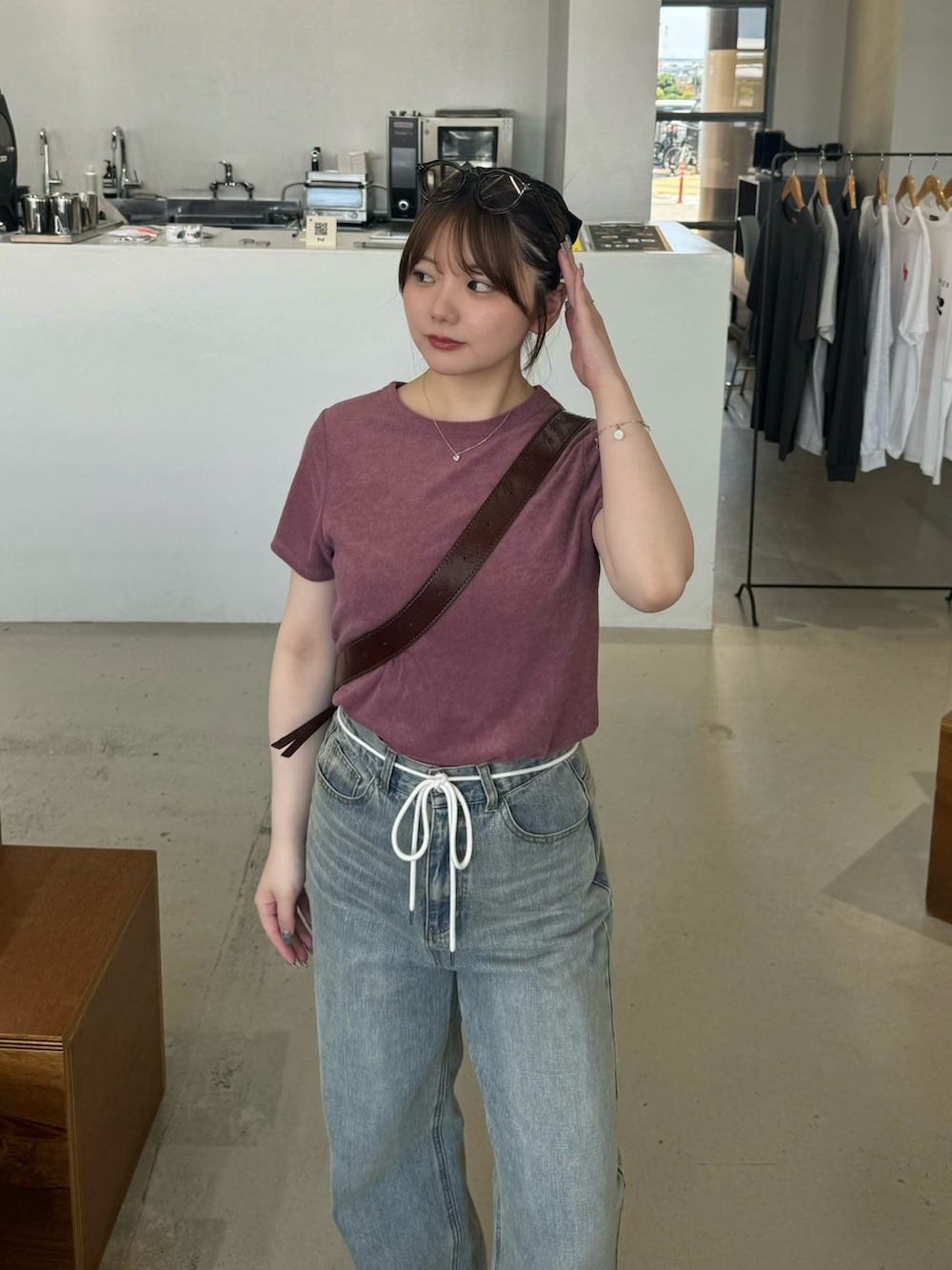 ブラウン系のショルダーバッグ、パープル系のTシャツ/カットソー、ブラウン系のサングラスを着用したレディースの夏コーディネートの3枚目の写真