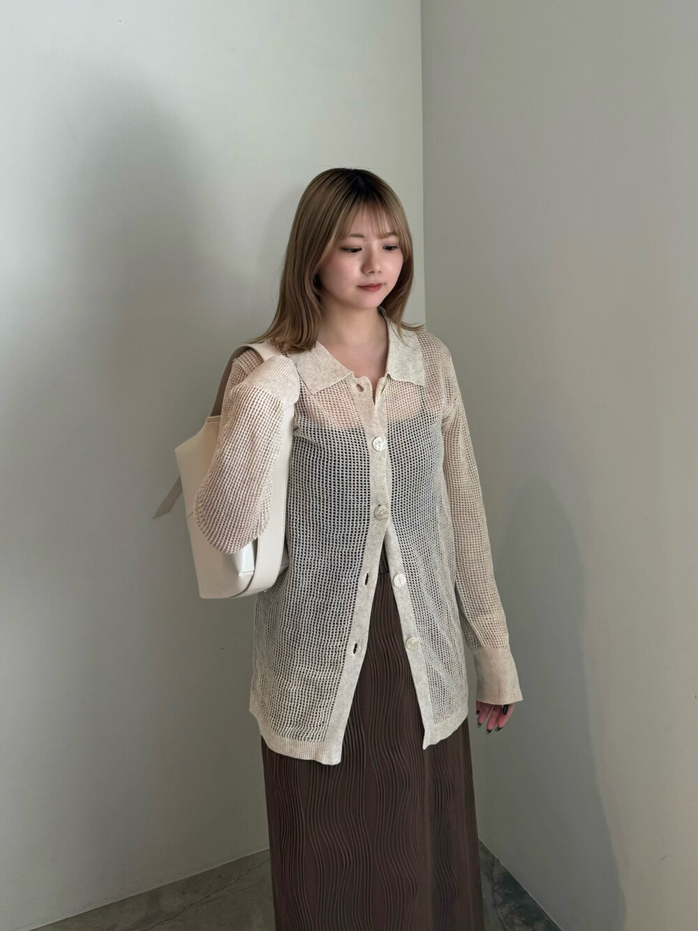 ベージュ系のカーディガン/ボレロ、ブラウン系のスカート、ホワイト系のサンダルを着用したレディースの春コーディネートの3枚目の写真