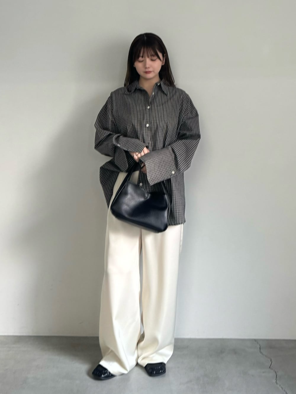 ブラック系のシャツ/ブラウス、ホワイト系のその他パンツ、ブラック系のハンドバッグを着用したレディースの春コーディネートの3枚目の写真
