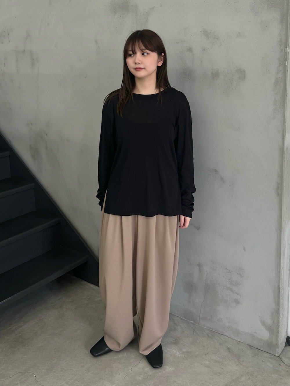 ブラック系のTシャツ/カットソー、ベージュ系のスラックスを着用したレディースの冬コーディネートの5枚目の写真