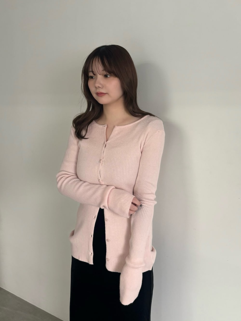 ピンク系のカーディガン/ボレロ、ブラック系のスカート、ブラック系のスリッポンを着用したレディースの冬コーディネートの3枚目の写真