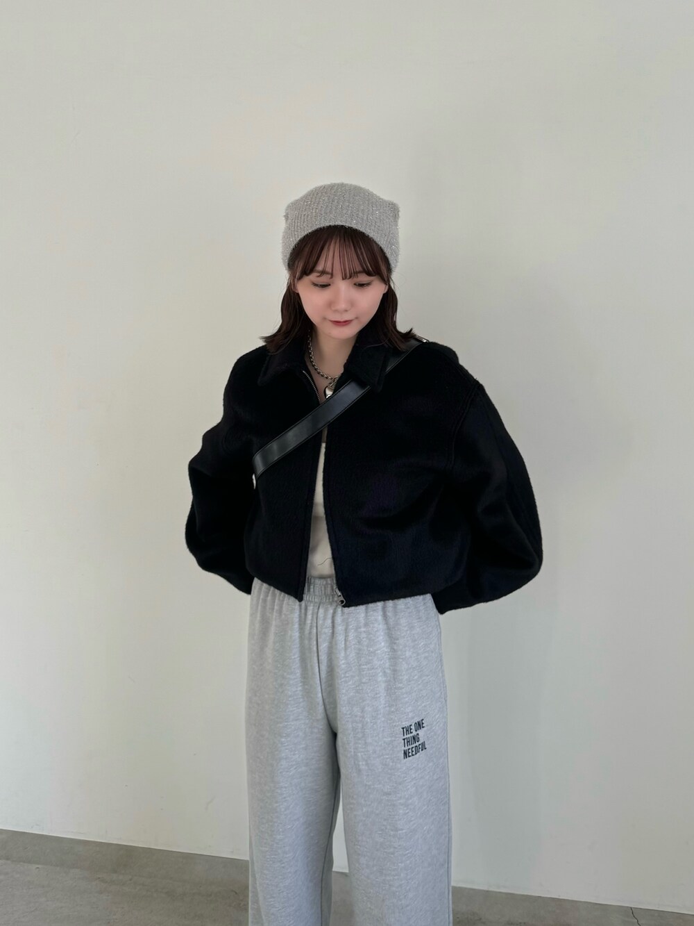 グレー系のスウェットパンツ、ブラック系のショルダーバッグ、ブラック系のステンカラーコートを着用したレディースの秋コーディネートの3枚目の写真