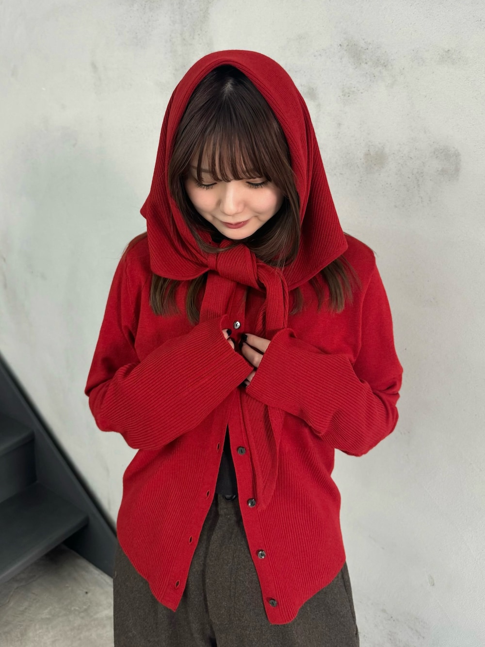 レッド系のニット/セーター、ブラウン系のその他パンツ、グレー系のスリッポンを着用したレディースの冬コーディネートの5枚目の写真