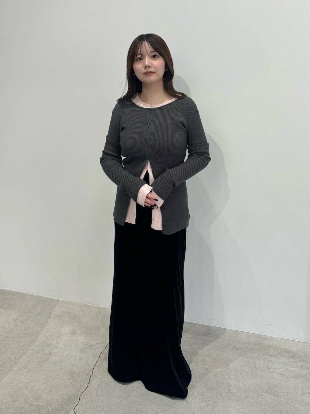 グレー系のカーディガン/ボレロ、ピンク系のカーディガン/ボレロ、ブラック系のスカートを着用したレディースの冬コーディネートの2枚目の写真