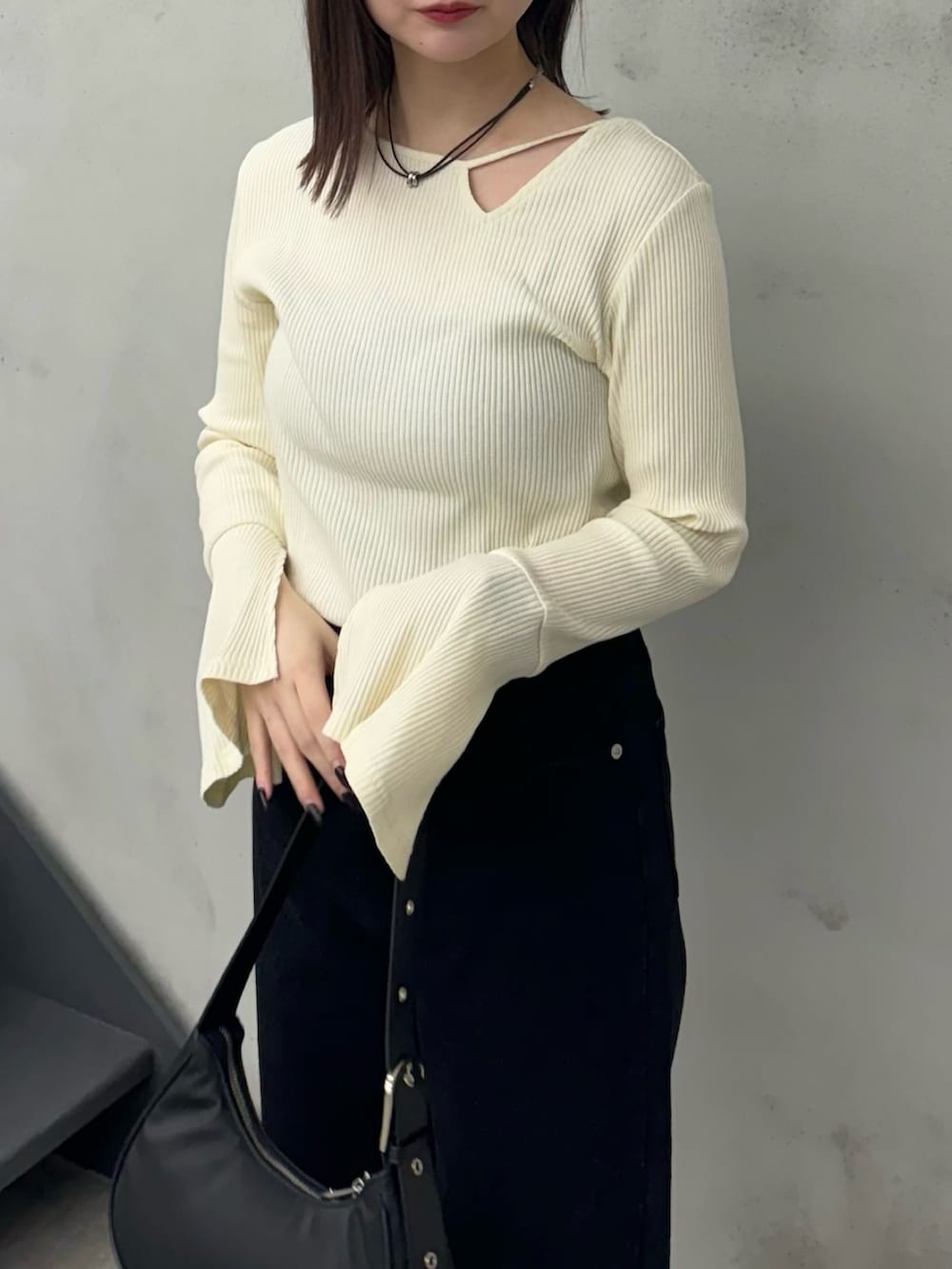 ブラック系のデニムパンツ、ブラック系のショルダーバッグ、ホワイト系のTシャツ/カットソーを着用したレディースの冬コーディネートの3枚目の写真