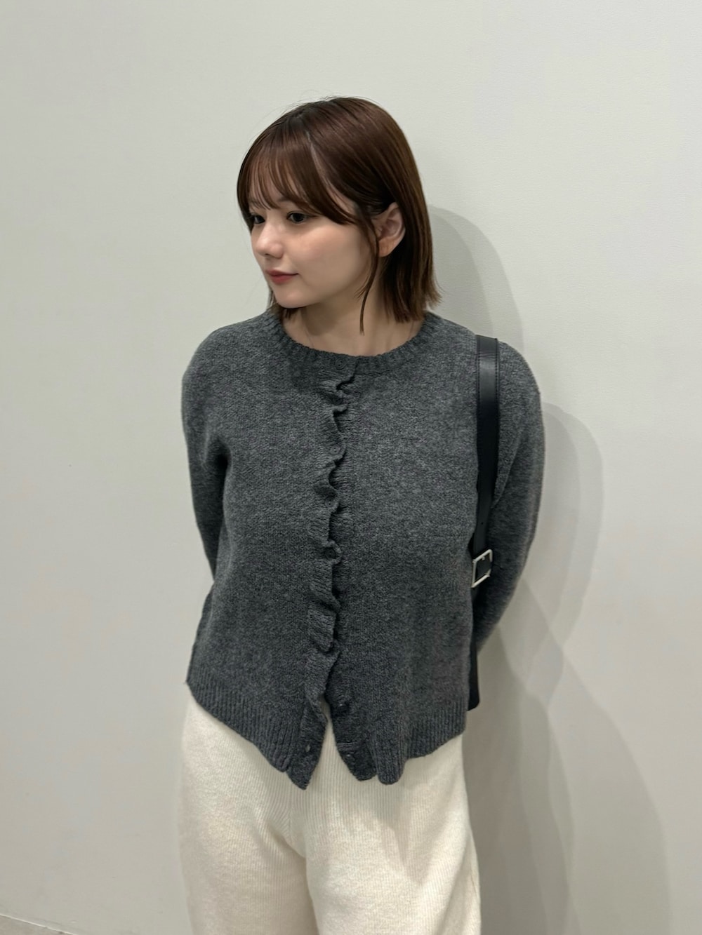 グレー系のカーディガン/ボレロ、ホワイト系のその他パンツ、ブラック系のスリッポンを着用したレディースの秋コーディネートの4枚目の写真