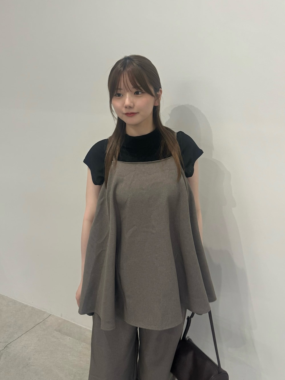 ブラウン系のキャミソール、ブラウン系のスラックス、ブラック系のTシャツ/カットソーを着用したレディースの夏コーディネートの4枚目の写真