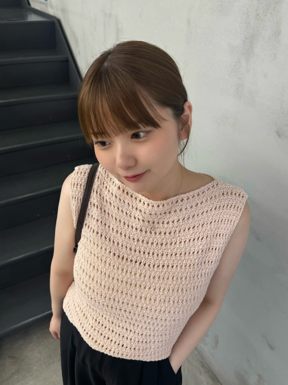 ピンク系のニット/セーター、ホワイト系のキャミソール、ブラック系のセットアップを着用したレディースの夏コーディネートの6枚目の写真