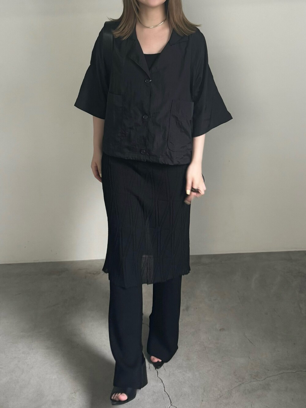 ブラック系のテーラードジャケット、ブラック系のキャミソール、ブラック系のスカートを着用したレディースの夏コーディネートの3枚目の写真