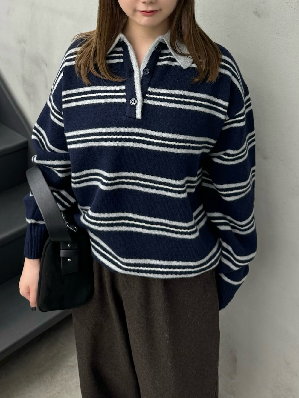 ブルー系のニット/セーター、ブラウン系のその他パンツ、ブラック系のハンドバッグを着用したレディースの秋コーディネートの3枚目の写真