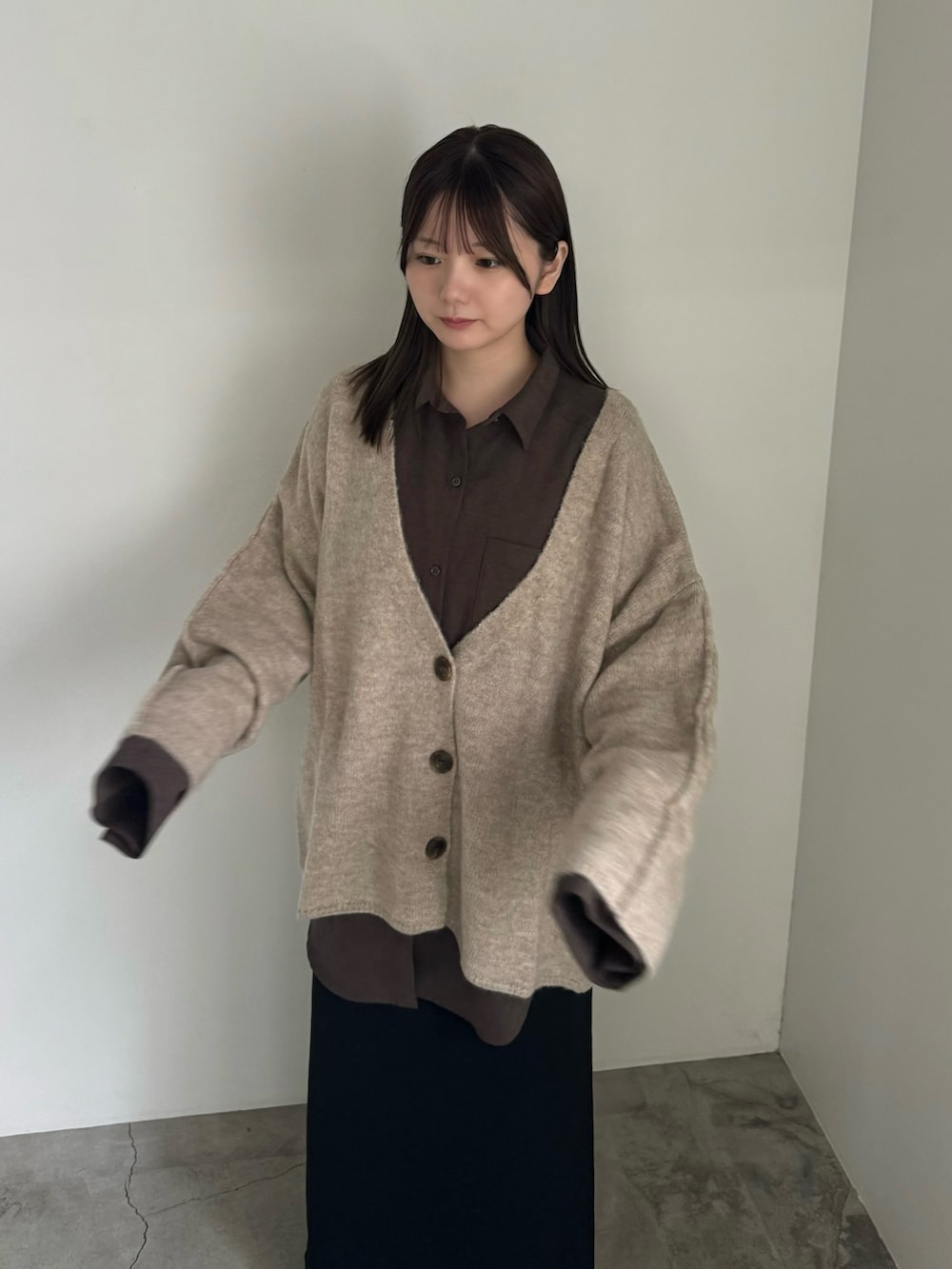 ベージュ系のカーディガン/ボレロ、ブラウン系のシャツ/ブラウス、ブラック系のスカートを着用したレディースの秋コーディネートの3枚目の写真