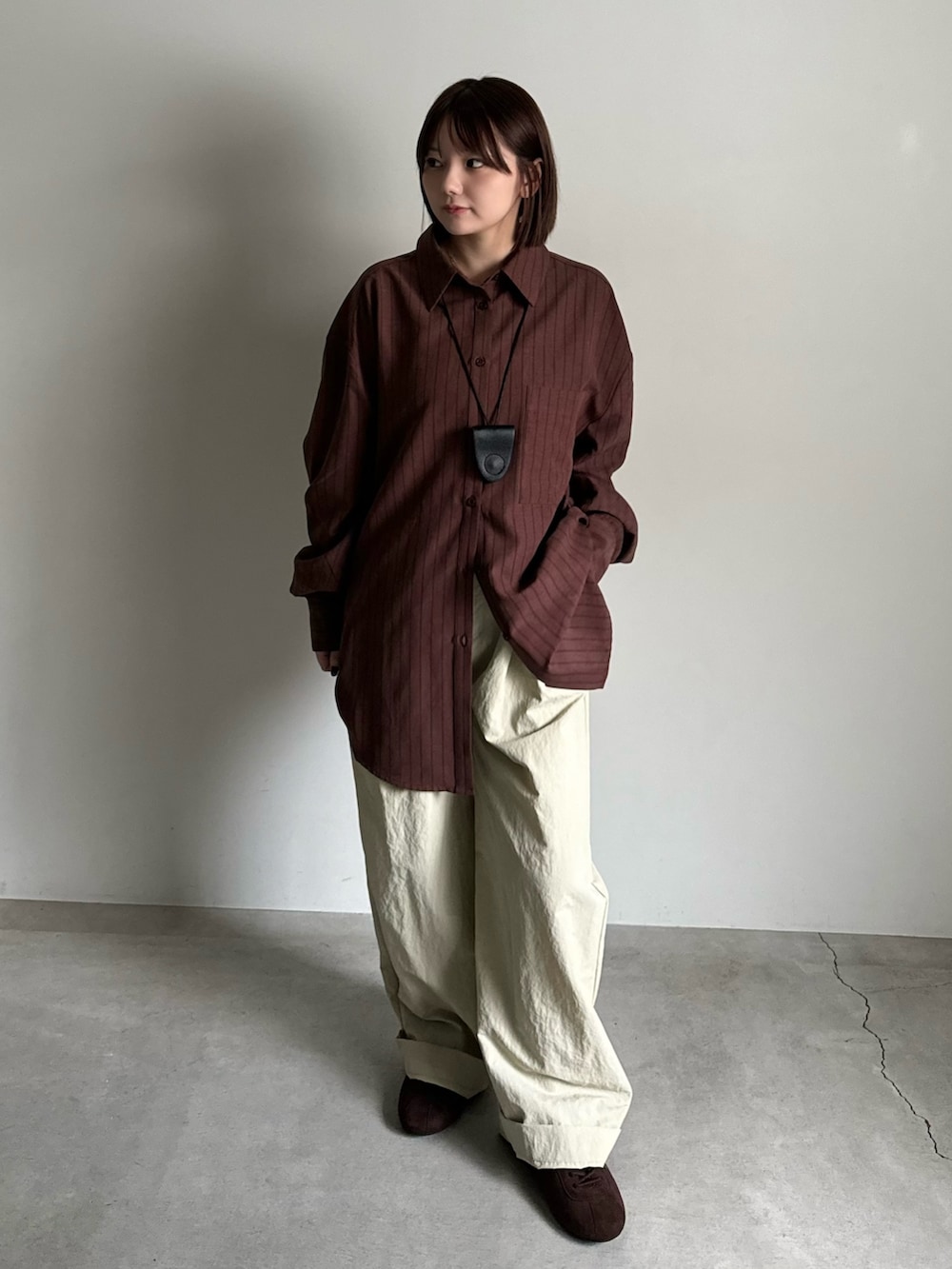 ブラウン系のシャツ/ブラウス、ベージュ系のその他パンツ、ブラック系のショルダーバッグを着用したレディースの夏コーディネートの2枚目の写真
