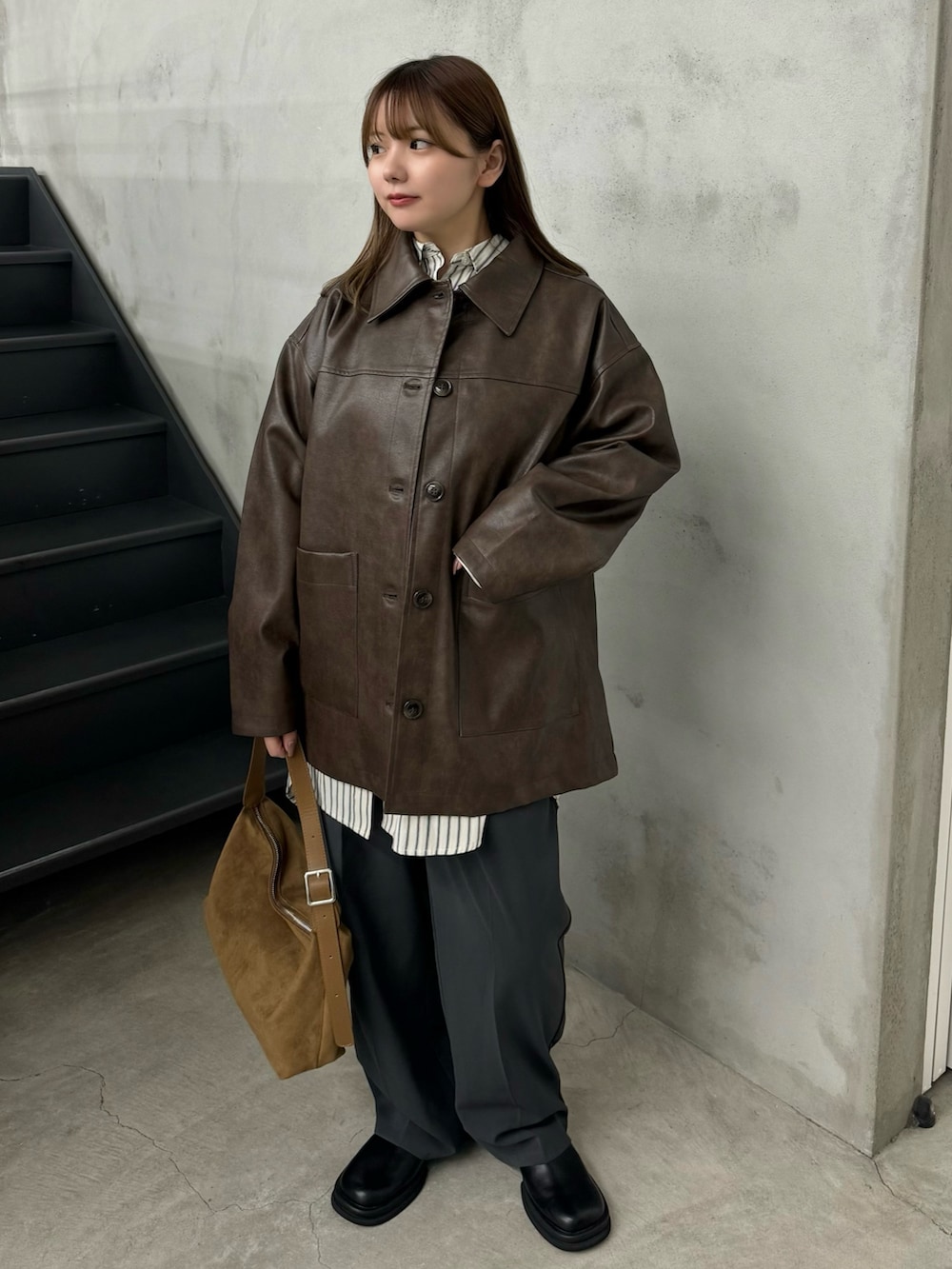 ブラウン系のステンカラーコート、ホワイト系のシャツ/ブラウス、グレー系のスラックスを着用したレディースの秋コーディネートの2枚目の写真