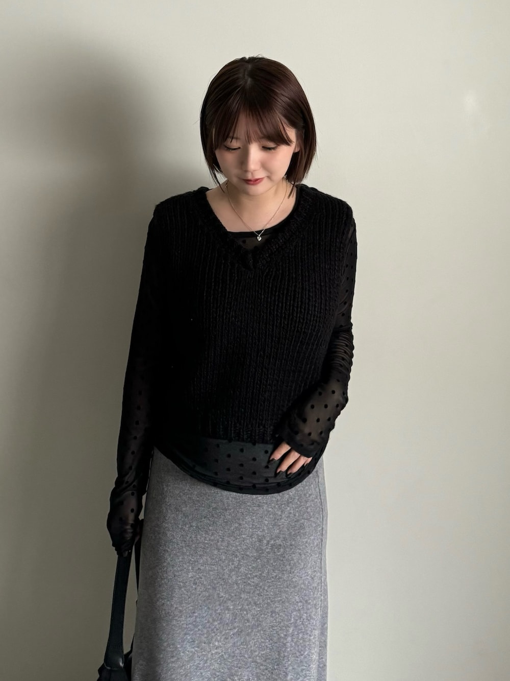 ブラック系のベスト、グレー系のスカート、ブラック系のTシャツ/カットソーを着用したレディースの秋コーディネートの4枚目の写真