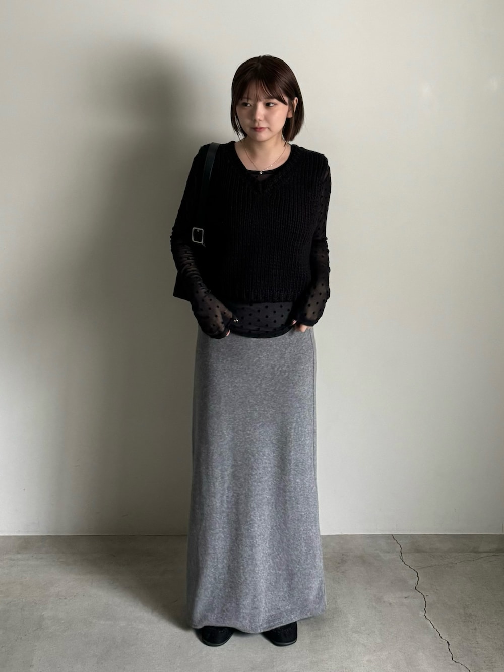 ブラック系のベスト、グレー系のスカート、ブラック系のTシャツ/カットソーを着用したレディースの秋コーディネートの2枚目の写真