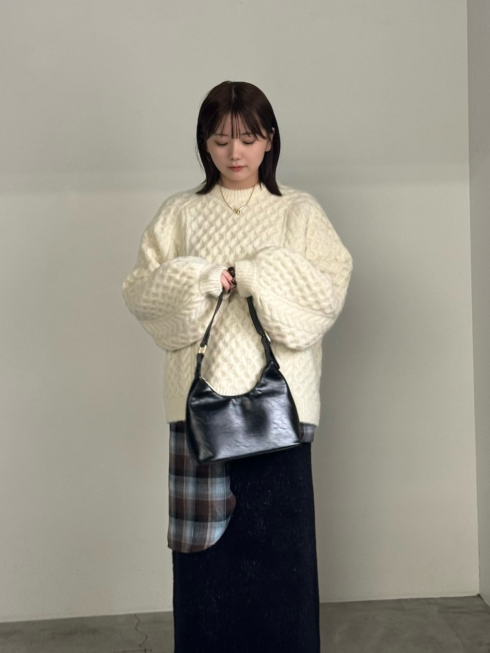 ホワイト系のニット/セーター、ブラウン系のシャツ/ブラウス、ブラック系のスカートを着用したレディースの秋コーディネートの2枚目の写真