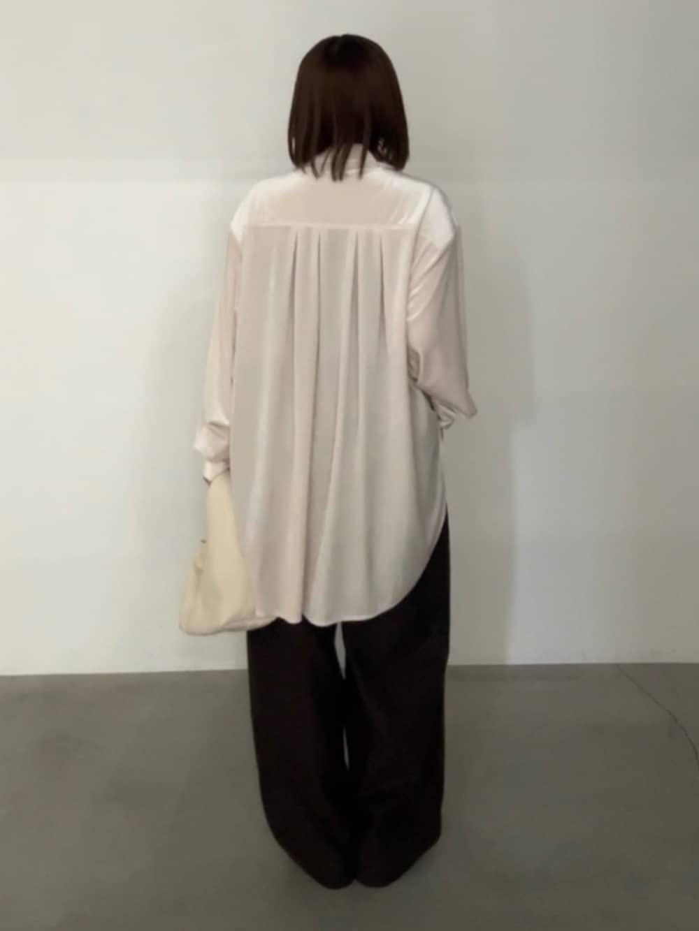 ベージュ系のシャツ/ブラウス、ブラウン系のスラックス、ベージュ系のハンドバッグを着用したレディースの秋コーディネートの3枚目の写真