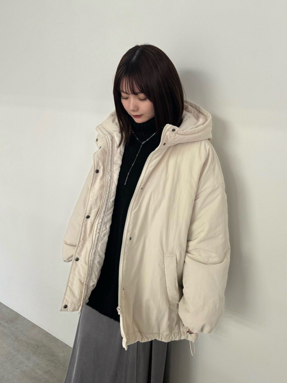 ホワイト系のダウンジャケット/コート、グレー系のスカート、ブラック系のブーツを着用したレディースの冬コーディネートの4枚目の写真