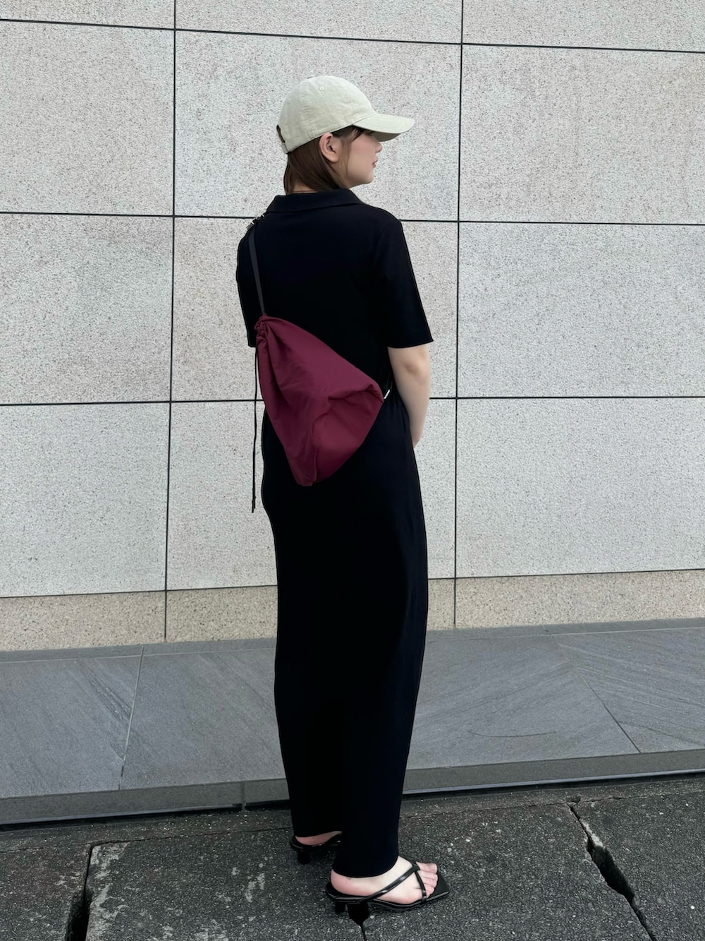 ブラック系のワンピース、レッド系のバックパック/リュック、ブラック系のサンダルを着用したレディースの夏コーディネートの2枚目の写真