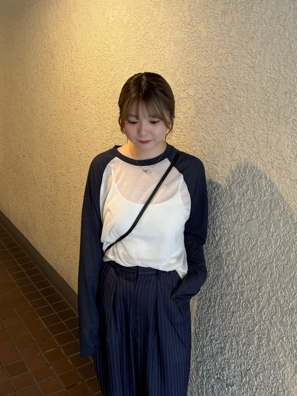 ブルー系のスラックス、ブルー系のTシャツ/カットソー、ホワイト系のキャミソールを着用したレディースの夏コーディネートの3枚目の写真