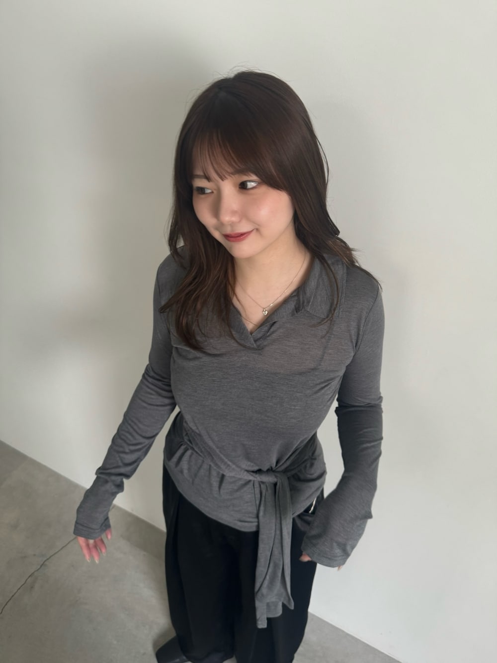 グレー系のTシャツ/カットソー、ブラック系のスラックス、ブラック系のスリッポンを着用したレディースの春コーディネートの8枚目の写真