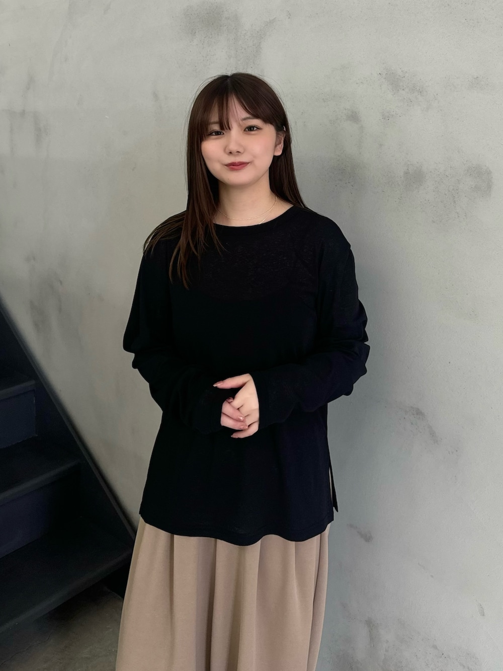 ブラック系のTシャツ/カットソー、ベージュ系のスラックスを着用したレディースの冬コーディネートの6枚目の写真