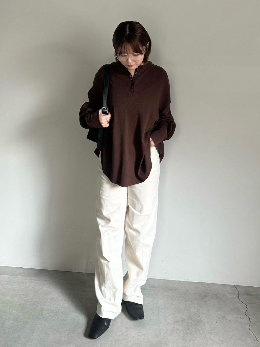 ブラウン系のTシャツ/カットソー、ベージュ系のその他パンツ、ブラック系のショルダーバッグを着用したレディースの秋コーディネートの2枚目の写真