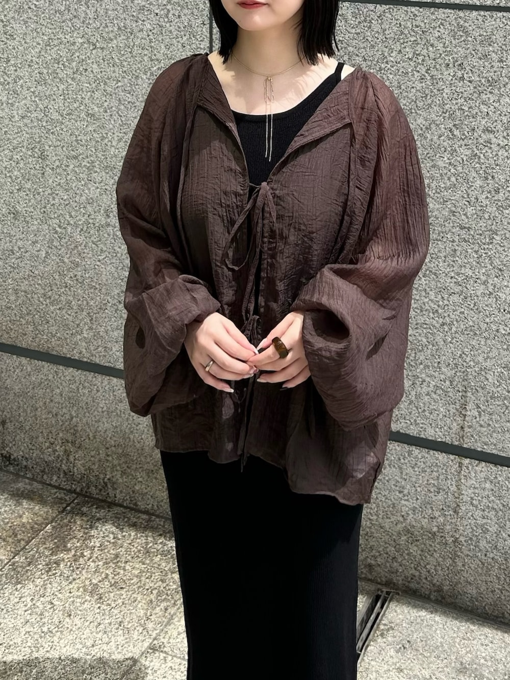 ブラウン系のシャツ/ブラウス、ブラック系のワンピース、ブラック系のサンダルを着用したレディースの夏コーディネートの4枚目の写真