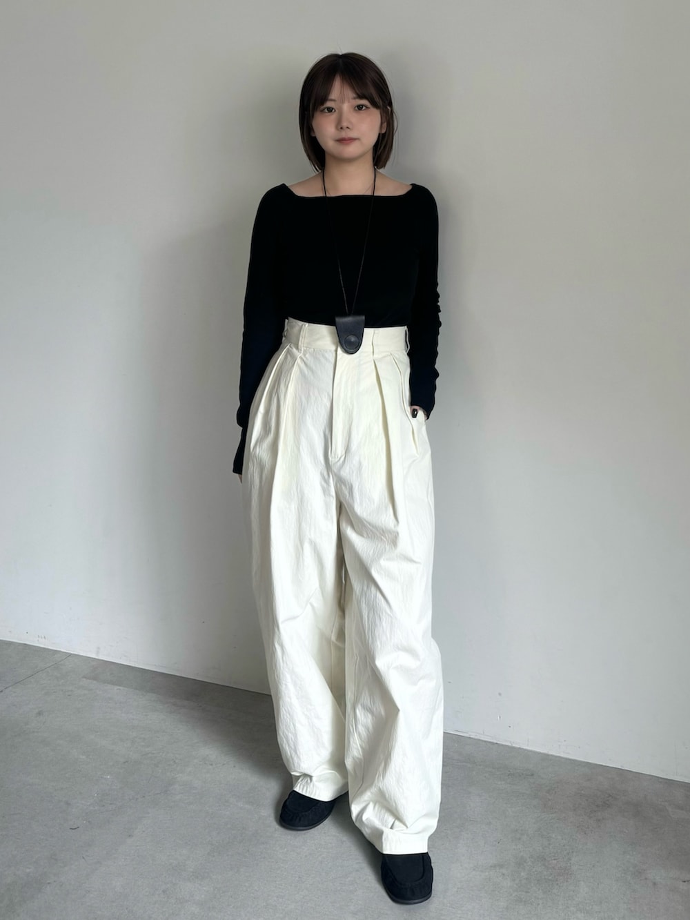 ブラック系のTシャツ/カットソー、ホワイト系のその他パンツ、ブラック系のローファーを着用したレディースの秋コーディネートの3枚目の写真