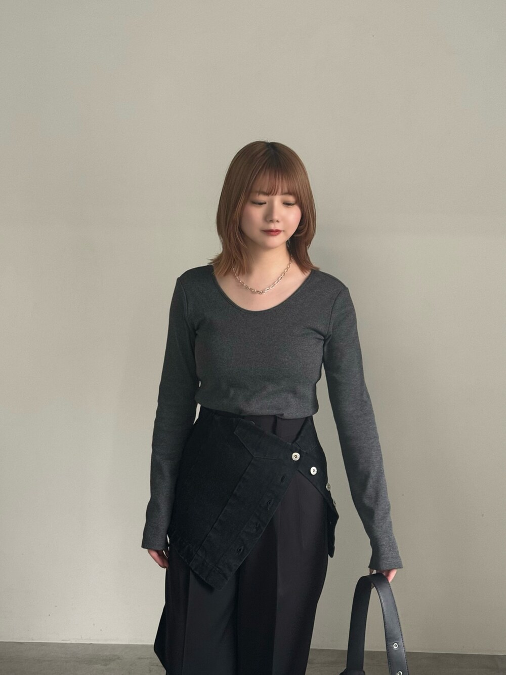 ブラック系のスラックス、ブラック系のチューブトップ、ブラック系のショルダーバッグを着用したレディースの春コーディネートの4枚目の写真