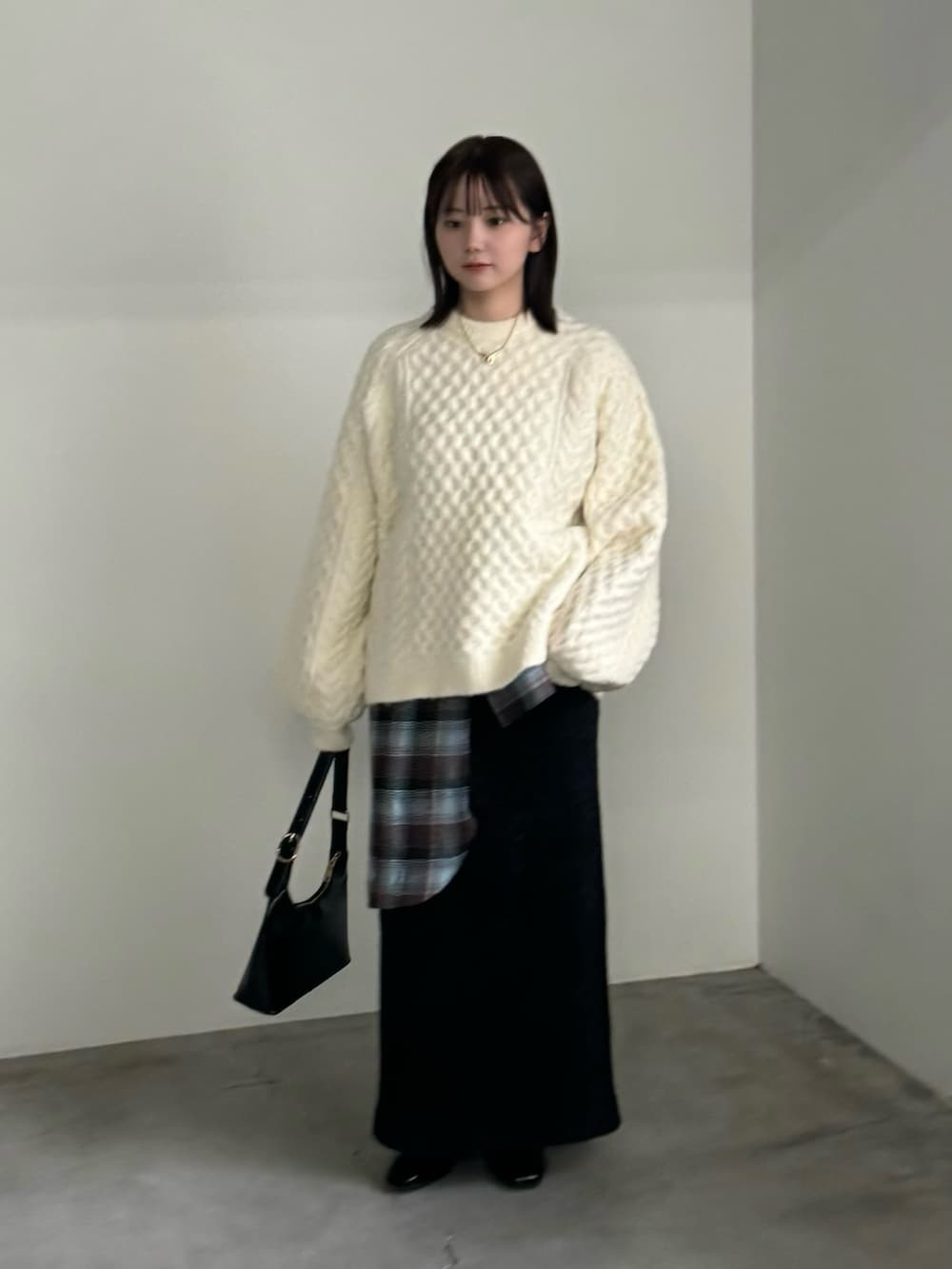 ホワイト系のニット/セーター、ブラウン系のシャツ/ブラウス、ブラック系のスカートを着用したレディースの秋コーディネートの3枚目の写真