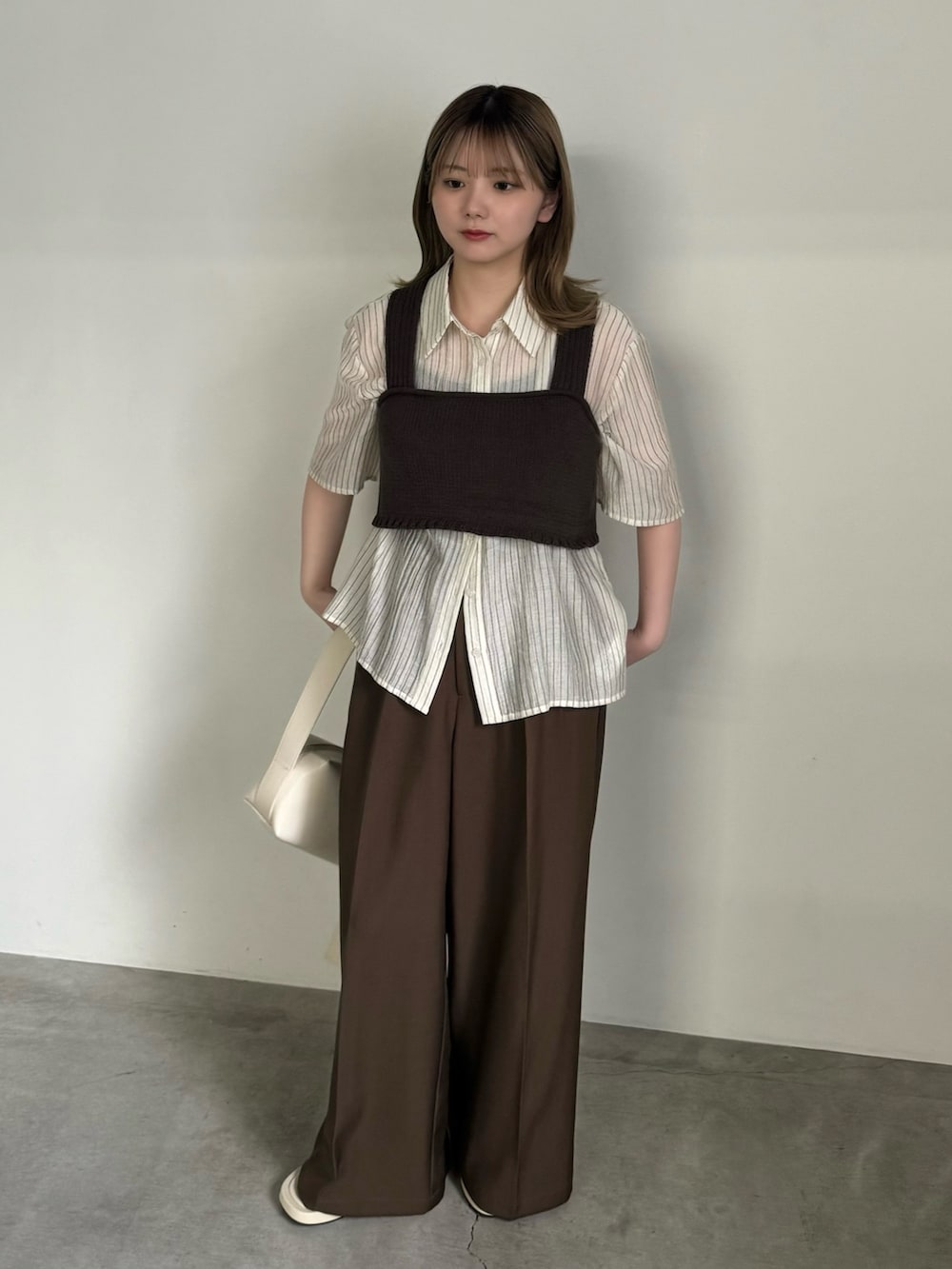 ホワイト系のシャツ/ブラウス、ブラウン系のベスト、ブラック系のキャミソールを着用したレディースの夏コーディネートの4枚目の写真